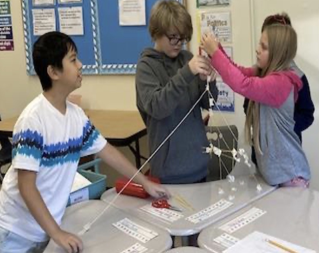 Sanford Middle School students in Ms Joy’s and Ms Wyman’s classes were using a yard of string, a yard of tape, 20 dry spaghetti pieces, and one jumbo marshmallow to build the tallest tower in 18 minutes. They had to work together & use strategy to create the tallest tower that could stand alone